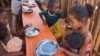 Children eat a meal at the Avotse feeding program that benefits malnourished children with hot meals in Maropia Nord village in the region of Anosy, southern Madagascar, Sept. 30, 2021. 