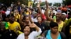 Members of the African National Congress (ANC) and mourners sing to celebrate the life of Nelson Mandela outside his old house in Soweto, Johannesburg, South Africa, Dec. 8, 2013.