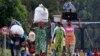 People displaced by fighting between Congolese forces and M23 rebels make their way home after spending a night in the Ugandan town of Bunagana, Oct. 31, 2013.