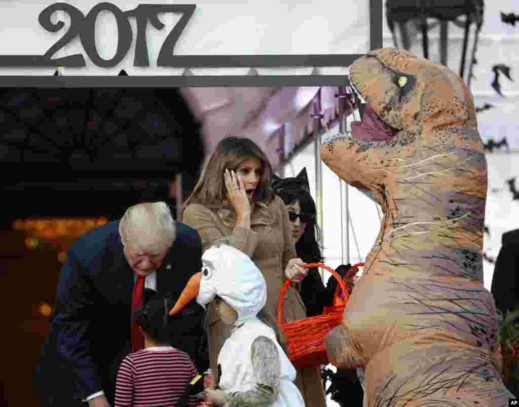 President Donald Trump and first lady Melania Trump hand out treats as they welcome children from the Washington area and children of military families to trick-or-treat celebrating Halloween, Oct. 30, 2017.