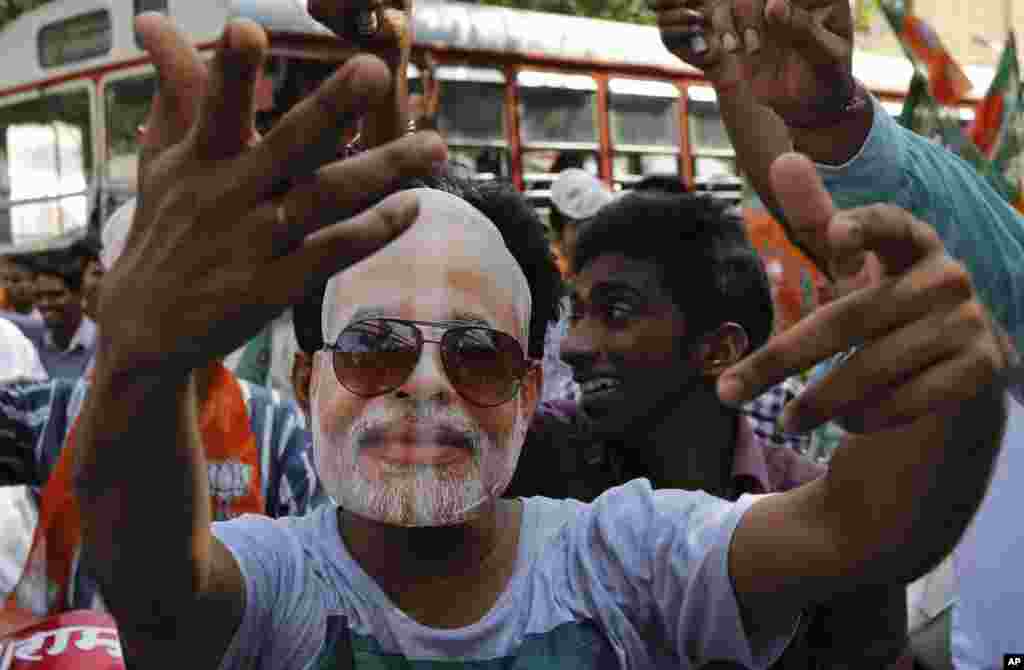 Bharatiya Janata Party supporters wearing masks of India’s next prime minister Narendra Modi, celebrate his inauguration in Mumbai, May 26, 2014.