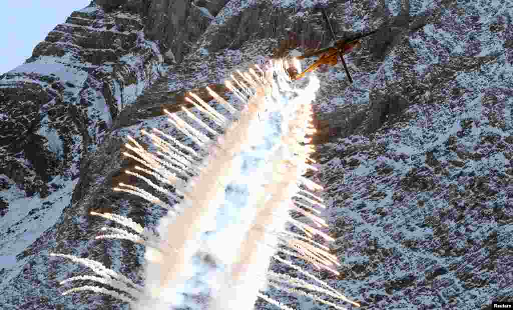 A Swiss Air Force Super Puma Cougar helicopter releases flares during a flight demonstration of the Swiss Air Force over the Axalp in the Bernese Oberland, Switzerland October 12, 2017.