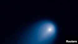 FILE - A comet is shown in this NASA handout photographed by the Hubble telescope, April 10, 2013. Two astronomers at Harvard say a comet that originated on the edge of the solar system struck Earth, triggering an event that wiped out the dinosaurs. 
