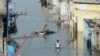 FILE - Flood-affected residents search for their belongings following heavy rains on the outskirts of Hyderabad, India, Oct. 20, 2020.