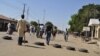 Vigilantes barricade a road after twin blasts exploded at a crowded market in Maiduguri, Nigeria, Dec. 1, 2014.