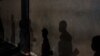 FILE - Shadows of Ugandan security personnel are seen in Kampala, Uganda, April 29, 2020. A Ugandan writer was reportedly arrested Friday for his work on an unpublished book that details his arrest and alleged torture in April by military personnel.