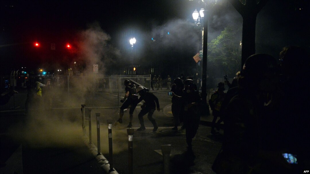 FILE - Police officers use tear gas during rally in Portland, Oregon, July 17, 2020. Rights activists and lawmakers expressed outrage over reports that federal agents in unmarked cars in the area were grabbing and detaining protesters off the streets.