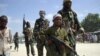 FILE - A young boy leads militant Islamist al-Shabab fighters as they conduct military exercises in northern Mogadishu's Suqaholaha neighborhood, Somalia, Jan. 1, 2010.