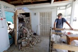 Eugene Johnson looks at the chimney collapsed by an earthquake the day before at his home in Trona, Calif., July 6, 2019. Crews in Southern California were assessing damage to buildings, roads, water and gas lines, and other infrastructure.