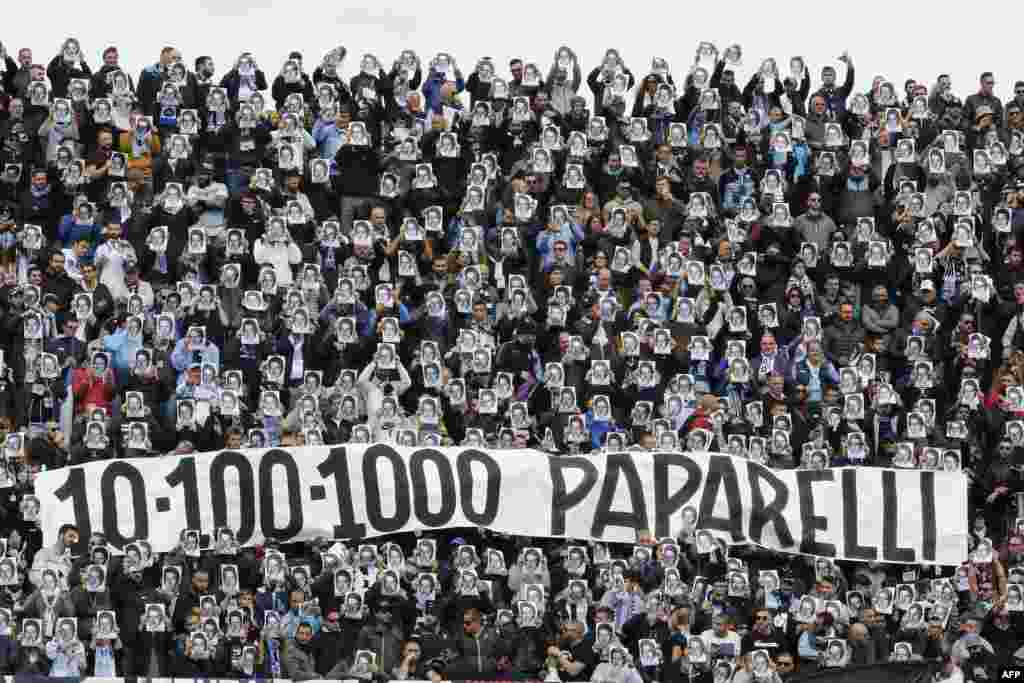 Lazio's fans hold portraits and a banner remembering Vincenzo Paparelli, a Lazio's fan killed by a flare in 1980, during the Italian Serie a football match Benevento Calcio vs SS Lazio at the Ciro Vigorito Stadium in Benevento, Italy.