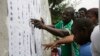 Nigerian people look for their names before they register to vote in Lagos, Nigeria, April 11, 2015. 