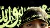 FILE - A boy stands before an Islamic jihad flag. Concern is growing in Germany and other countries that the Islamic State group, now largely weakened, is actively recruiting children to carry on their jihadist legacy. 