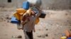 FILE - A boy carries buckets to fill with water from a public tap amid an acute shortage of water Oct. 13, 2015, on the outskirts of Sanaa, Yemen.
