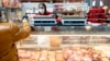 FILE - A customer pays for a cut of meat at Union Meat Company in Eastern Market in Washington, DC, on Feb. 8, 2022.