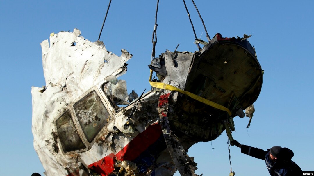FILE - Local workers transport a piece of the Malaysia Airlines flight MH17 wreckage at the site of the plane crash near the village of Hrabove (Grabovo) in Donetsk region, eastern Ukraine, Nov. 20, 2014.