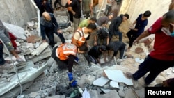 Palestinians search for casualties at the site of Israeli strikes on houses in Jabalia refugee camp at the Indonesian hospital, in the northern Gaza Strip