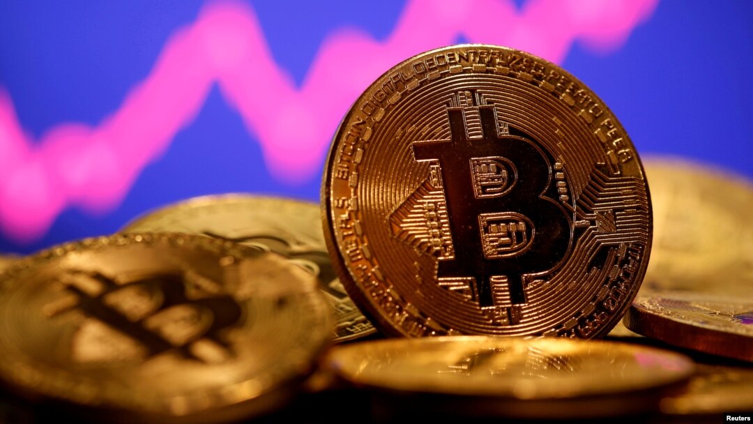 FILE - A representation of virtual currency bitcoin is seen in front of a stock graph in this illustration taken Jan. 8, 2021.