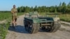"UkrPrototyp" dizayn va ishlab chiqarish byurosining bosh direktori Andriy Denysenko Ukraina shimolidagi makkajo'xori dalasida 800 kilogrammlik quruqlikdagi avtonom harakatlanuvchi transport prototipi yonida, 2024 yil, 28-iyun.