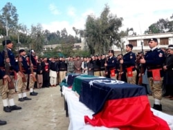 Pakistani police officers attend the funeral for their colleagues in Lower Dir, Dec. 18, 2019. Gunmen shot and killed the two policemen who were part of the most recent anti-polio drive in the volatile northwest.