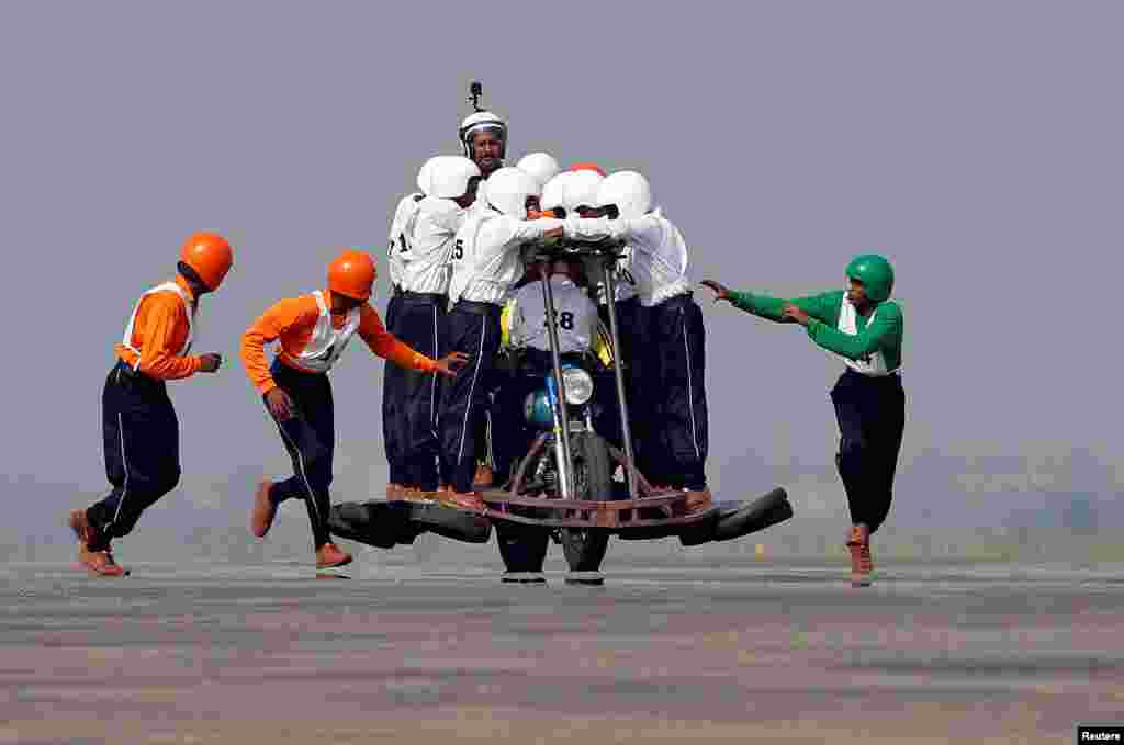 Members of Army Service Corps (ASC) &quot;Tornadoes&quot;, the motorcycle display team of the Indian army, run to climb onto a motorcycle as they attempt to create a world record for most men on a single moving motorcycle at the Yelahanka Air Force Station in Bengaluru, India.