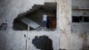 Palestinians look out of their house that was damaged in an Israeli air strike, in Gaza City, Nov. 13, 2018. 