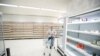 FILE: A customer pushes her trolley next to empty shelves at a Sainsbury's store during the COVID-19 outbreak, in Harpenden, Britain, March 18, 2020.