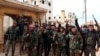 In this photo released Feb. 16, 2020 by the Syrian official news agency SANA, Syrian army soldiers flash the victory sign in the Rashideen neighborhood, in Aleppo province, Syria. 