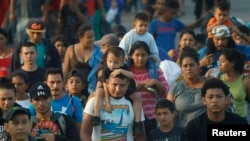 FILE - Hundreds of Central American migrants walk together on the highway, after crossing the Guatemala-Mexico border, near Ciudad Hidalgo, Mexico, June 5, 2019.