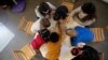 FILE - Children play with a therapist in the pediatric unit of the Robert Debre hospital, in Paris, France.