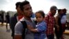 Un migrante salvadoreño carga a su hizo en territorio de Guatemala camino hacia Estados Unidos el 18 de enero de 2020.