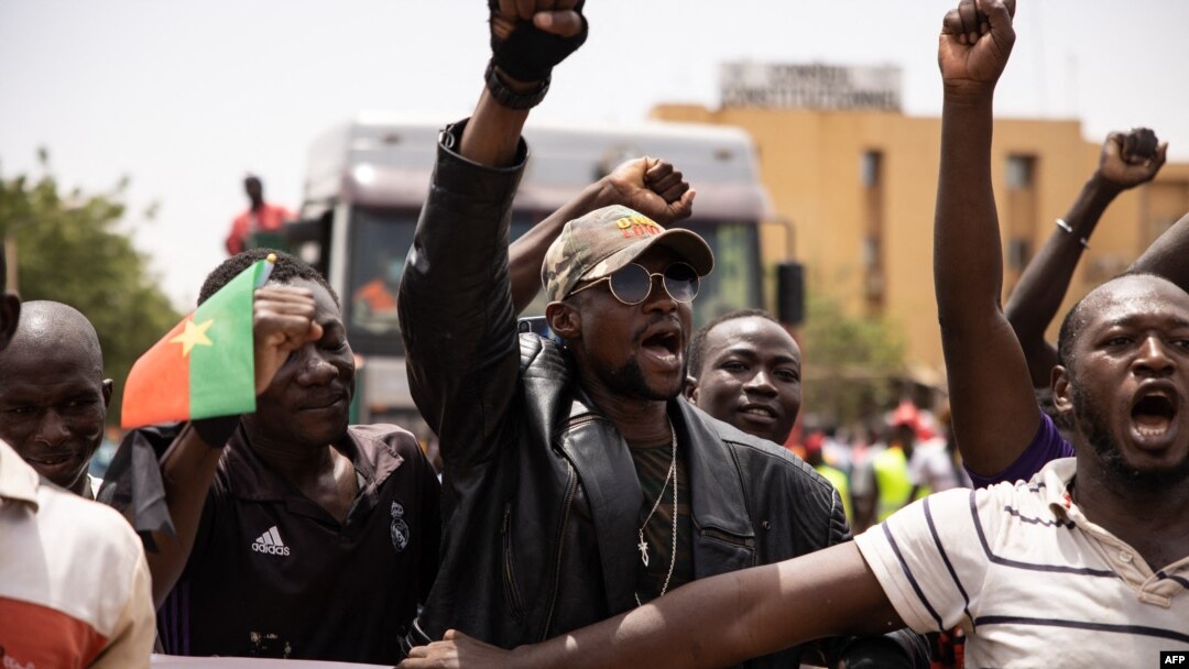 FILE - People take part in a march called by the opposition to protest the worsening security situation and ask for a response to jihadist attacks, in Ouagadougou, Burkina Faso, July 3, 2021.
