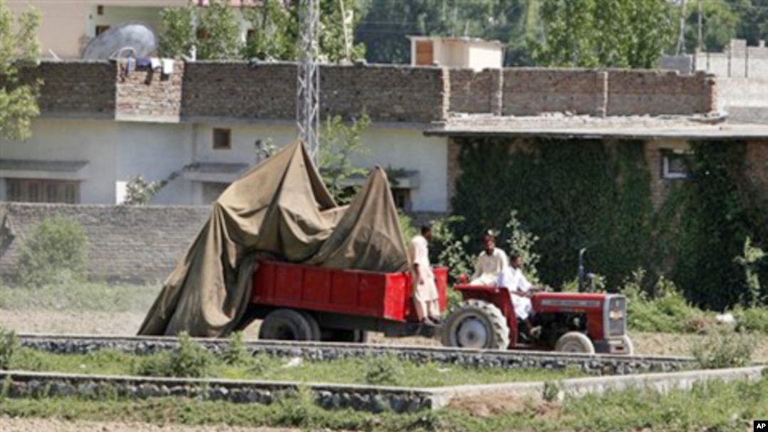 The wreckage of a US helicopter that crashed next to the wall of the bin Laden compound in Abbottabad being transported by Pakistani officials, May 2, 2011