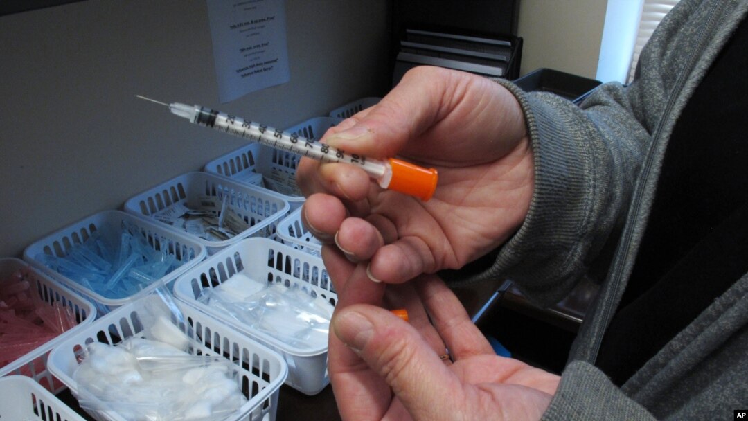 FILE - A nurse for eastern Indiana's Fayette County holds one of the syringes provided to intravenous drug users taking part in the county's state-approved needle exchange program in Connersville. The effort is in response to a hepatitis C outbreak among IV drug users.