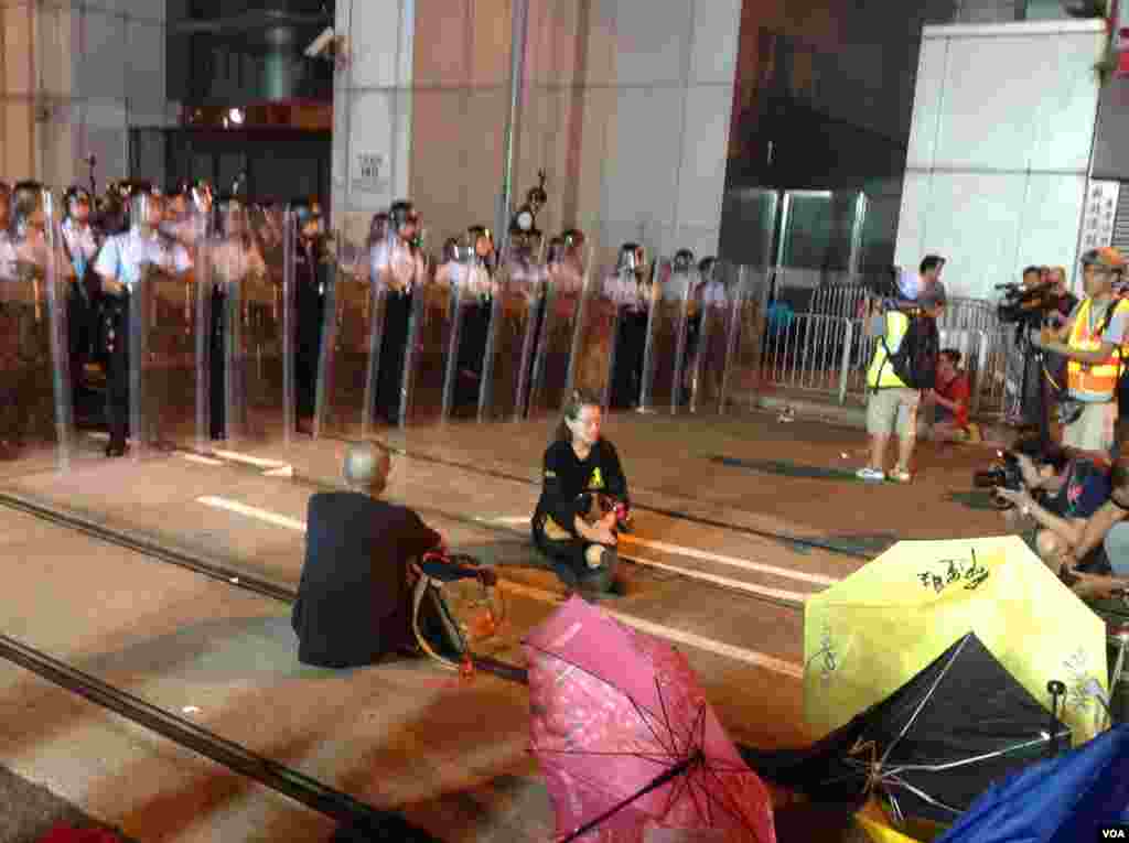 从10点前,在中联办外德辅道西上的警察由手持约一米七高的长盾牌的防暴警察替换到最前排,做好准备清场的准备。示威者则用铁马和雨伞筑成防线,应对警方的清场。另外,在西边街,也有一些示威者与警方对峙,但场面没有在德辅道上紧张。目前,现场仍有近千人。