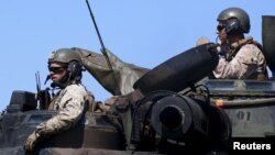 FILE - U.S. Marines sit atop an amphibious assault vehicle during exercises with Philippine marine troops in joint drills at a Philippine Naval base San Antonio, Zambales, Oct. 9, 2015.