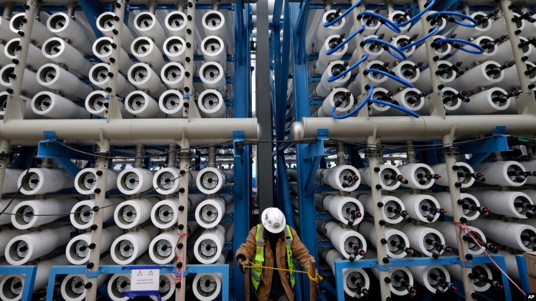 FILE - A worker climbs stairs among some of the 2,000 pressure vessels that will be used to convert seawater into fresh water through reverse osmosis in a desalination plant in Carlsbad, Calif.