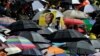 A portrait of Nelson Mandela is seen through a sea of umbrellas during the memorial service for former South African president Nelson Mandela at the FNB Stadium in Soweto, near Johannesburg on Dec. 10, 2013.