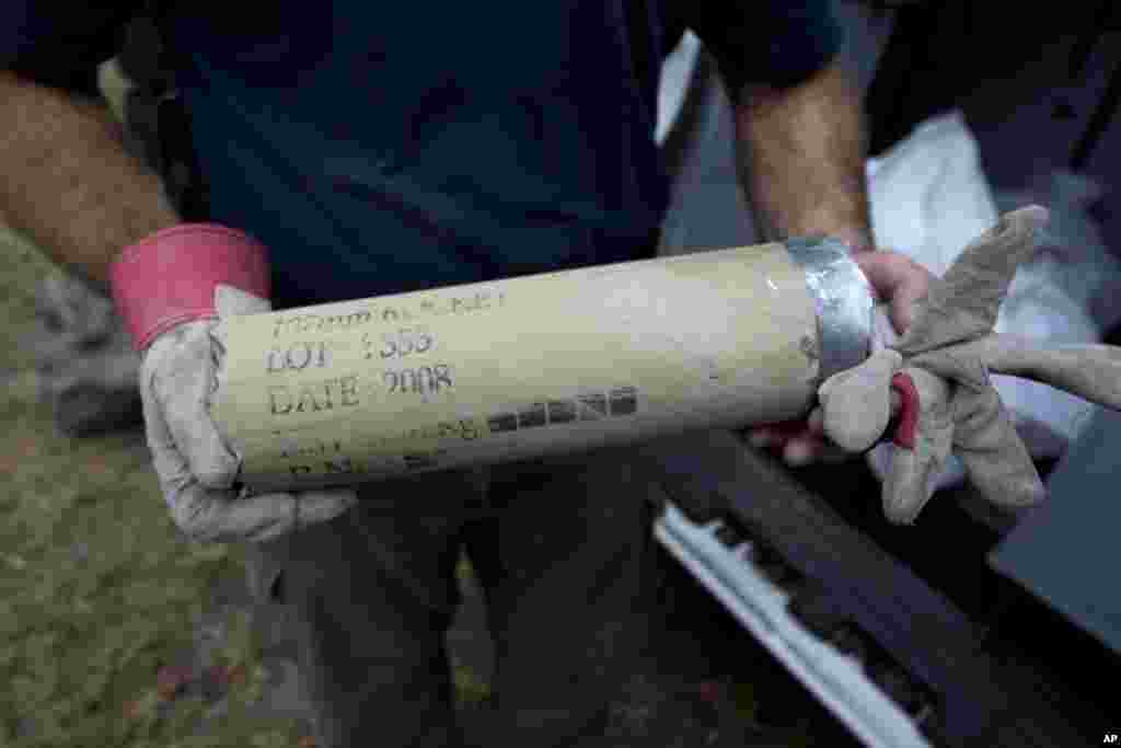 An Israeli police man holds the remains of a rocket fired by Palestinian militants after it hit a community along the Israel - Gaza Border, southern Israel, October 24, 2012.