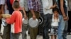 Nepalese people queue to receive food and goods at a relief camp for survivors of the Nepal earthquake in Kathmandu, May 19, 2015.