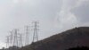 FILE - Electricity pylons snake across a hill in a Johannesburg suburb.