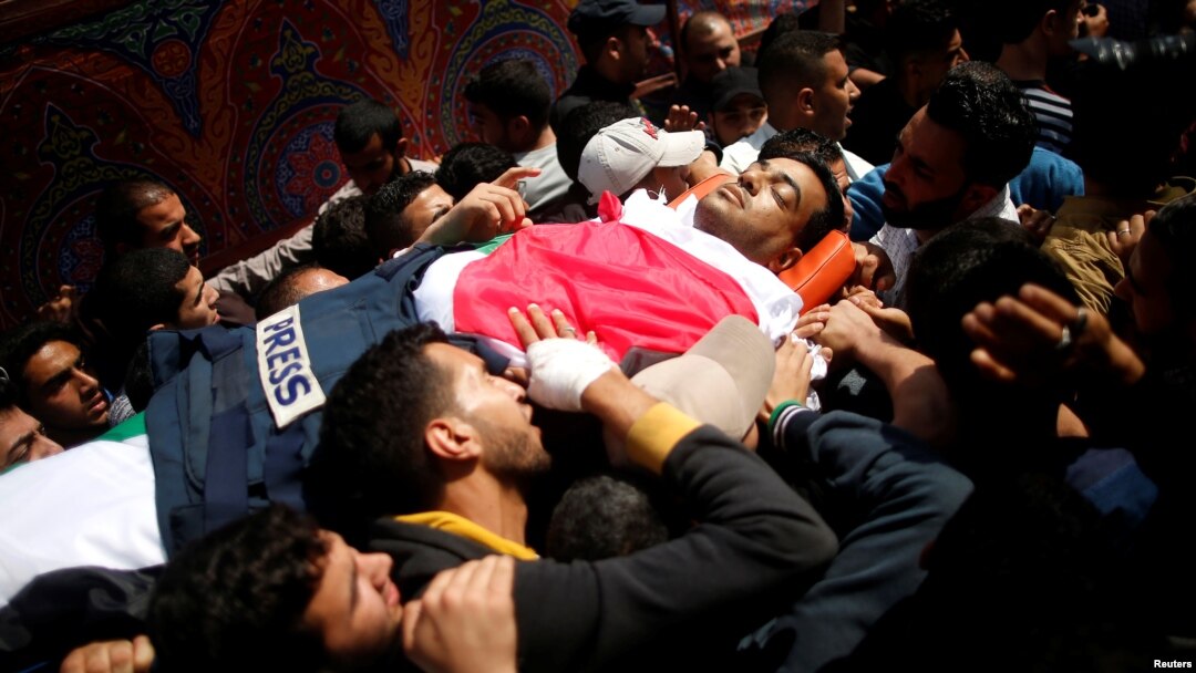 Colleagues of Palestinian journalist Yasser Murtaja, 31, who died of his wounds during clashes at the Israel-Gaza border Friday, carry his body during his funeral in Gaza city, April 7, 2018.