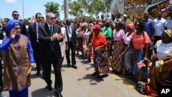 FILE - Turkey's President Recep Tayyip Erdogan and his wife, Emine Erdogan, greet local people during a ceremony in Maputo, Mozambique, Jan. 24, 2017. 