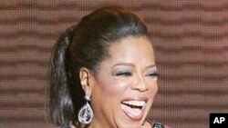 In this May 17, 2011 photo, Oprah Winfrey acknowledges fans during a star-studded double-taping of "Surprise Oprah! A Farewell Spectacular," in Chicago