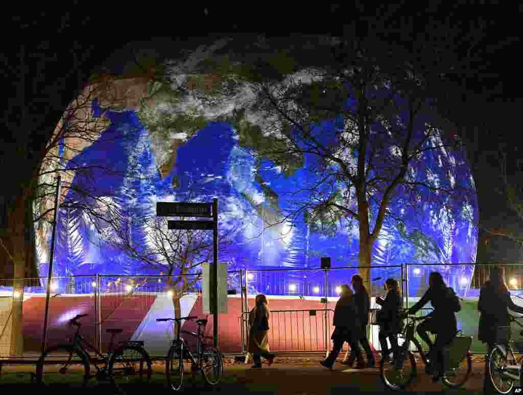 People pass the German pavilion in the shape of the earth during the COP 23 Fiji UN Climate Change Conference in Bonn, Germany.