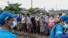 FILE - People wait to receive bags of rice distributed by the World Food Program as part of food aid efforts to support residents living in poor communities on the outskirts of Yangon, Myanmar, May 21, 2021.