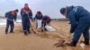 In this photo taken from video released by Russian Emergency Ministry Press Service on Jan. 4, 2025, workers clean fuel oil that spilled out of two tankers more than two weeks ago in the Kerch Strait in Russia's Krasnodar region. (Russian Emergency Ministry Press Service via AP)