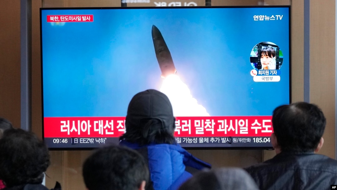 18일 한국 서울역 이용객들이 북한 탄도미사일 발사 TV 뉴스를 시청하고 있다.