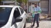 FILE - A driver of an electric car charges his vehicle at public charging station in New Delhi, India, April 1, 2021. 