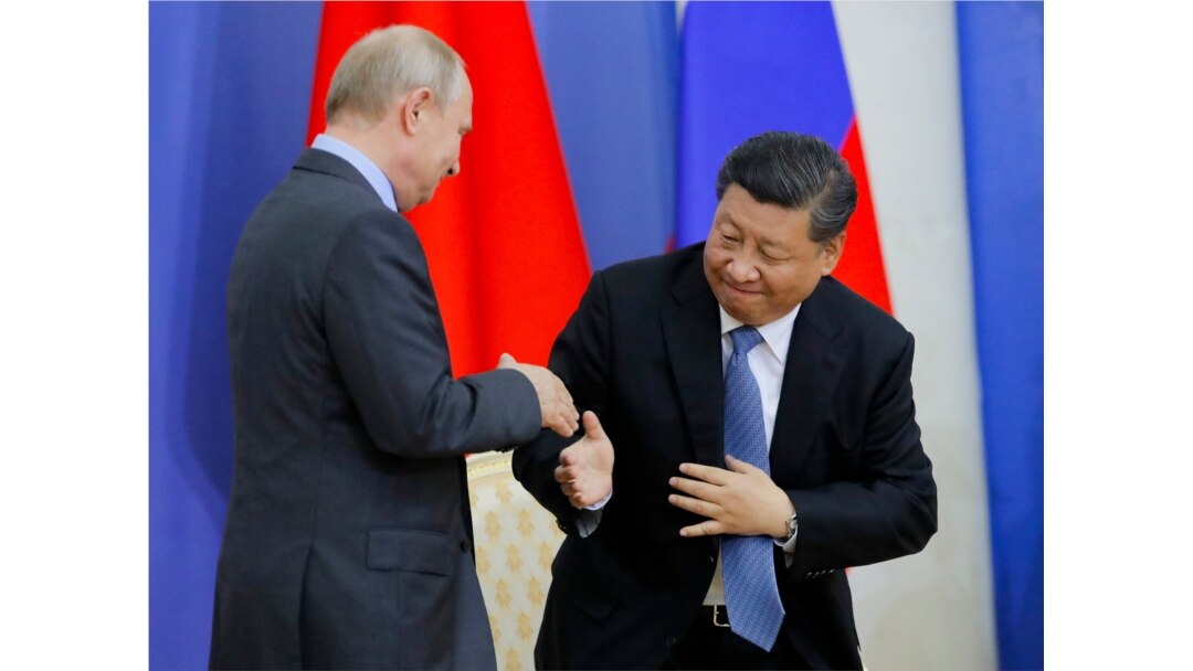 FILE - Chinese President Xi Jinping and Russian President Vladimir Putin shake hands during a ceremony at which Xi was presented with an honorary degree from St. Petersburg State University in St. Petersburg, Russia, June 6, 2019.