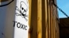 FILE - A sticker reads "Toxic" is seen on containers carrying Syria's dangerous chemical weapons, on the Danish cargo ship, Ark Futura, transporting them out of the strife-torn country, in Cyprus coastal waters, May 13, 2014.